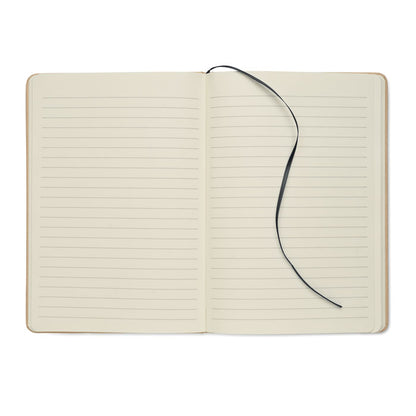 Libreta A5 abierta con marcapáginas negro y hojas de papel reciclado rayado