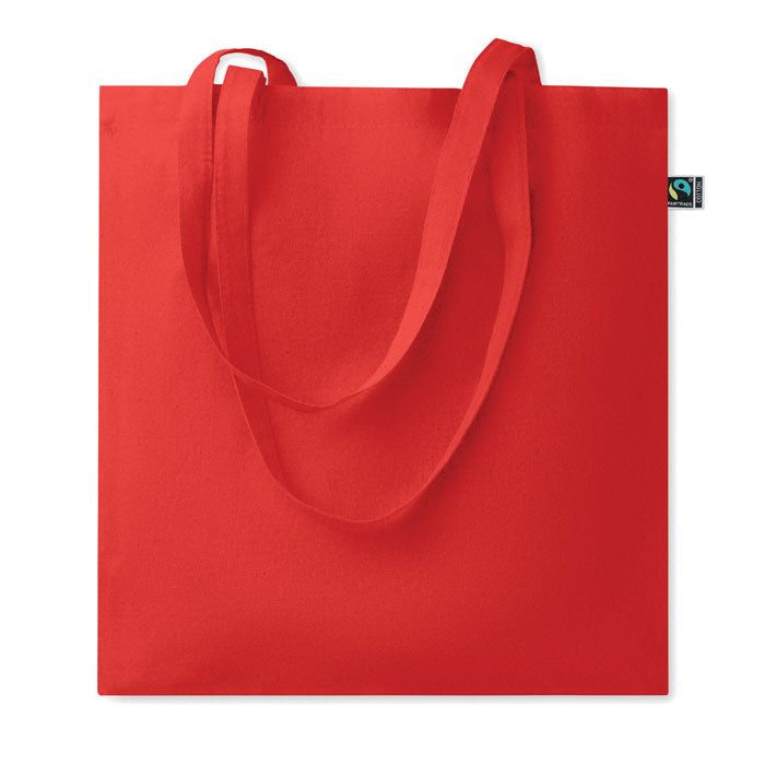 Bolsa de algodón Fairtrade de 180gr en color rojo, con asas largas y diseño simple.