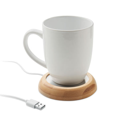 Vista frontal de taza blanca sobre calentador con USB