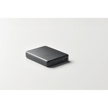 Vista lateral de power bank pequeña negra con fondo gris