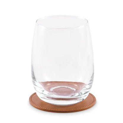 Vaso de cristal sobre posavasos redondo marrón