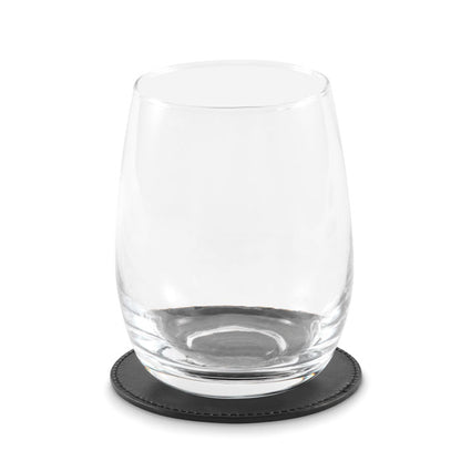 Vaso de cristal sobre posavasos redondo negro