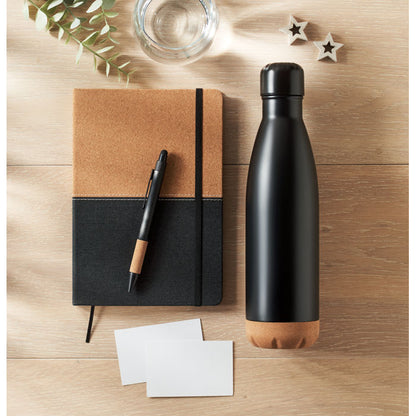 Vista superior de mesa de madera con botella+boli+libreta, negro con detalles de corcho