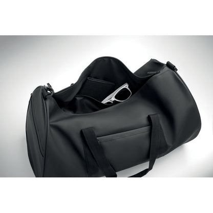 Bolsa negra abierta de fin de semana mostrando gafas de sol y billetero