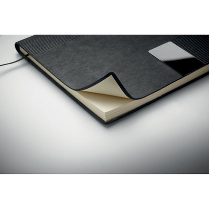 Detalle de esquina de libreta negra con hojas color crema