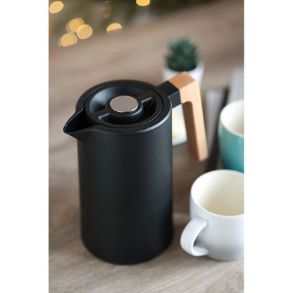 Foto ambiente de jarra de acero negra asa de madera sobre mesa con 2 tazas