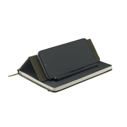 Móvil colocado en libreta verde con soporte