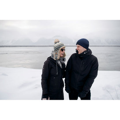 Hombre y mujer con gorros de punto en paisaje nevado