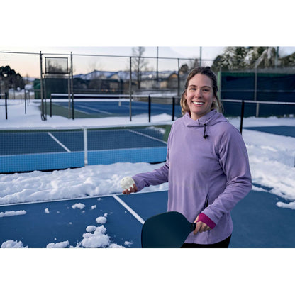 Mujer jugando al pickleball en una cancha nevada