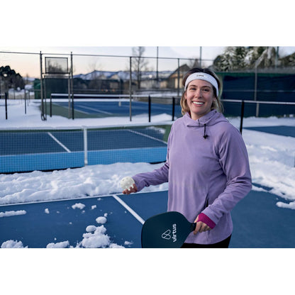 Chica sujetando una pala y pelota de pickleball personalizada con logotipo