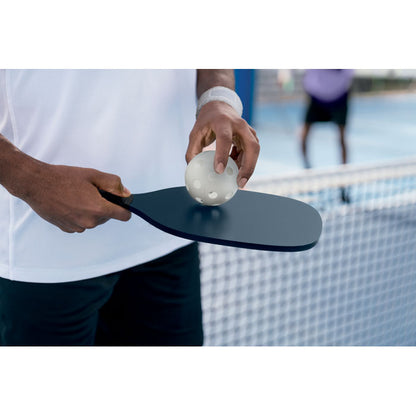 Hombre sujetando una pala y una pelota de pickleball