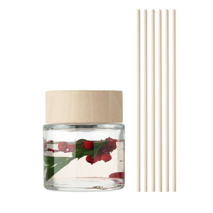 Bote con ambientador y flores y varillas de madera