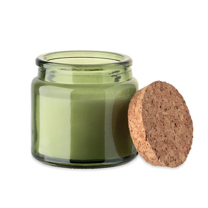 Tarro de vidrio con vela color verde con tapa de corcho a un lado