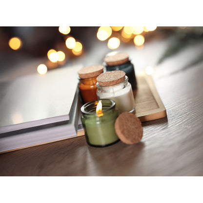 4 velas, verde encendida, blanca, ambar y negra an tarro con tapa de corcho