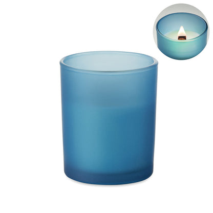 Vista superior de vela de vidrio color azul con mecha de madera encendida