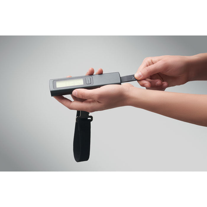 VOYAGE - Báscula digital para equipaje en uso, mostrando las manos sosteniendo el dispositivo de forma práctica.