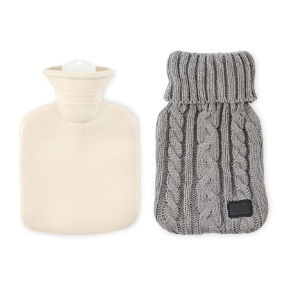 Mesa de madera con manta marrón y bolsa de agua caliente de punto gris