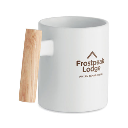 Vista superior de taza blanca de cerámica con detalle de madera en asa