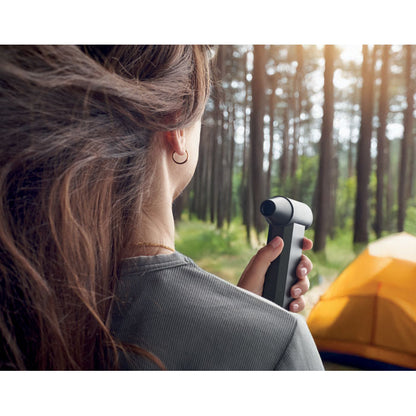 MUjer con turboventilador de mano aplicandose aire a la cara