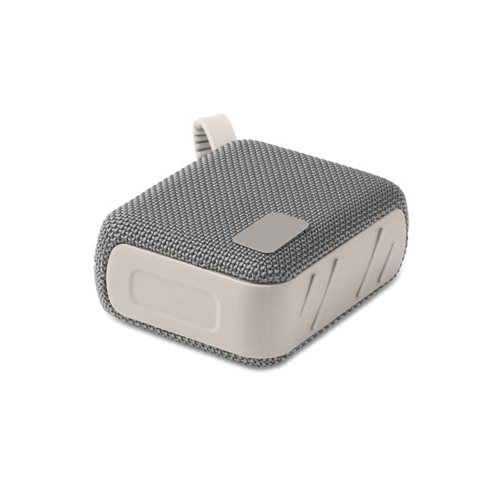 Vista lateral del altavoz inalámbrico de 5 W en color gris, con acabado textil y base de ABS, ideal para llevar a cualquier lugar.
