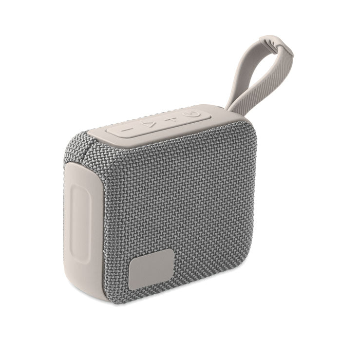 Vista lateral de un altavoz inalámbrico de 5 W en color gris, con diseño texturizado y cable para colgar.