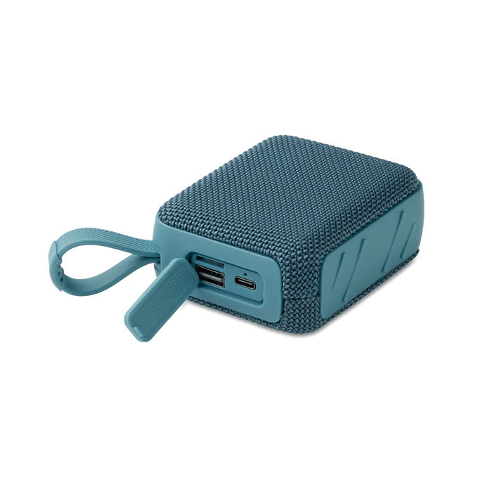 Vista lateral del altavoz inalámbrico de 5 W, mostrando puertos de carga USB y un diseño texturizado en color azul.
