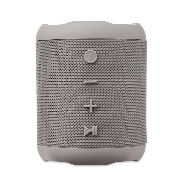 Vista frontal de un altavoz inalámbrico ABS de color gris, con botones de control de volumen y reproducción.