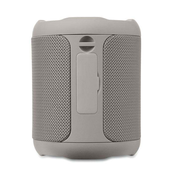 Vista frontal del altavoz inalámbrico de 5 W en color gris, con textura de malla y botón de control incluido.