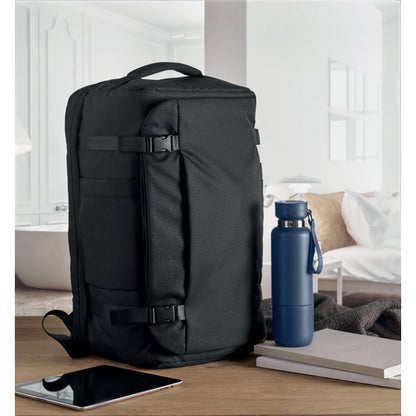 mesa con bolsa de viaje grande negra, botella, tablet y libretas