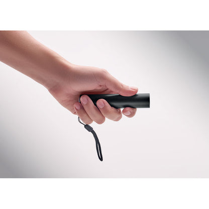 Mano sujetando linterna recargable negra