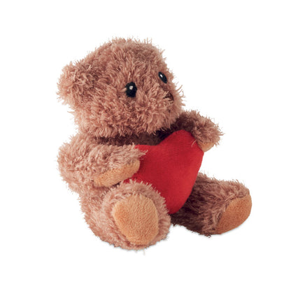 Osito de peluche sentado con corazón rojo en el centro