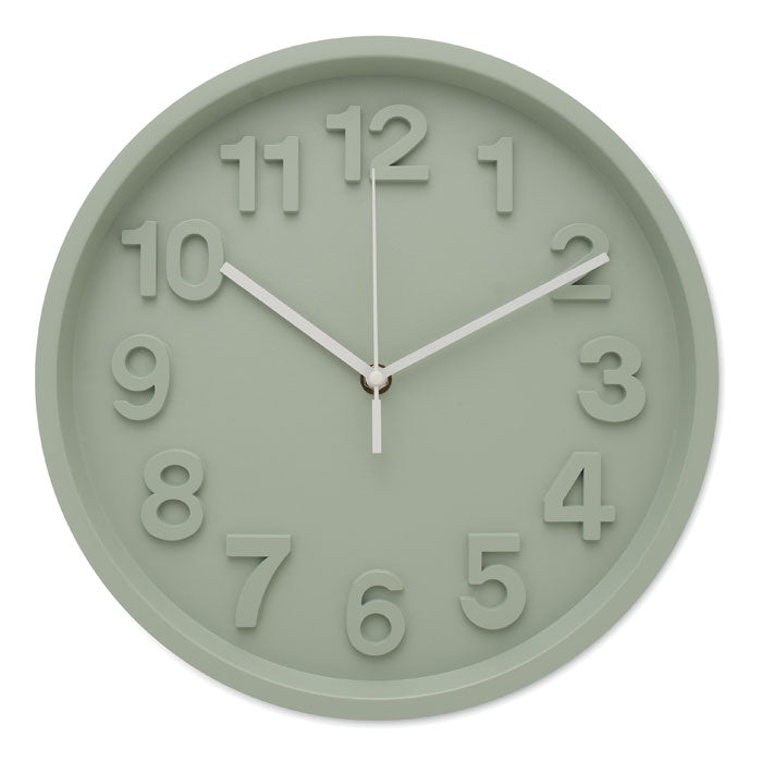 Diseño minimalista de reloj de pared en verde menta con cifras en relieve y agujas blancas, ideal para decoración moderna.