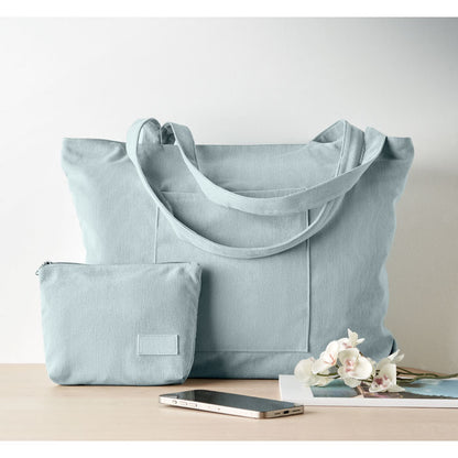 Bolsa azul claro vista frontal con objetos alrededor