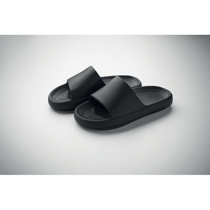 Chanclas negras de EVA sobre fondo gris