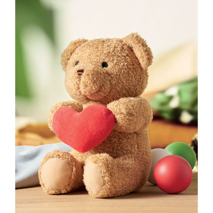 Osito de peluche con corazón rojo en ambiente decorado