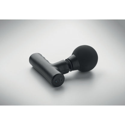 Pistola de masaje con accesorios sobre superficie