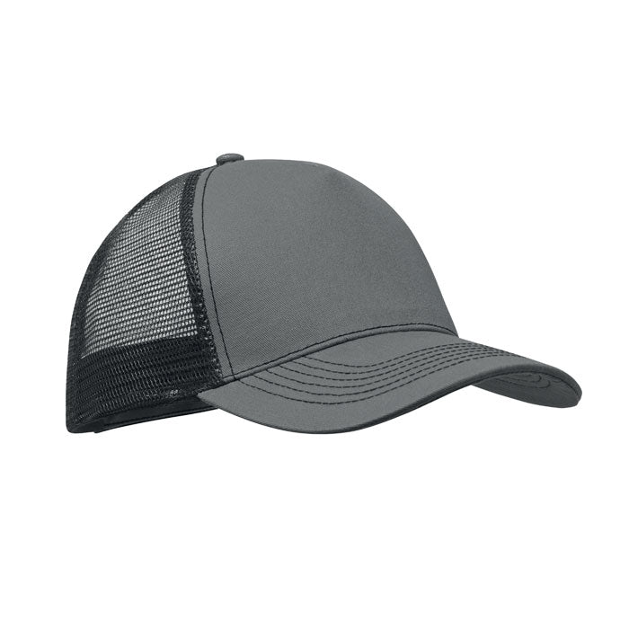 Vista lateral de gorra trucker de 5 paneles en color gris piedra con visera de algodón y malla trasera negra.
