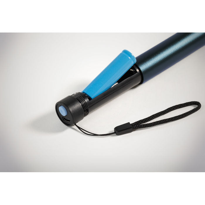 Detalle de linterna recargable de aluminio con batería destacada y cable de carga en su base, ideal para uso diario.
