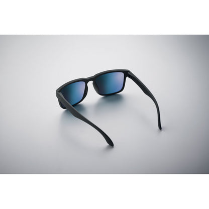 Gafas de sol con lentes azules sobre fondo claro