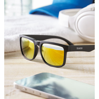 Gafas con lentes espejo amarillas sobre superficie clara