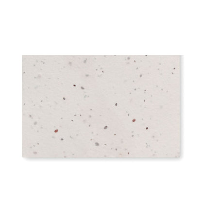 Tarjeta de visita de papel con semillas sobre fondo claro