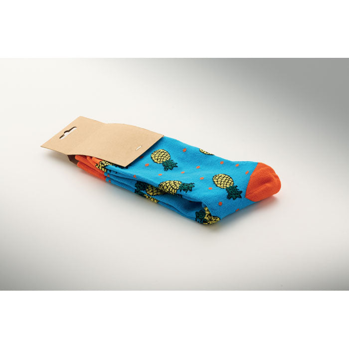 FUNNY M - Calcetines estampados alegres con diseño de piñas en fondo azul y punta naranja.