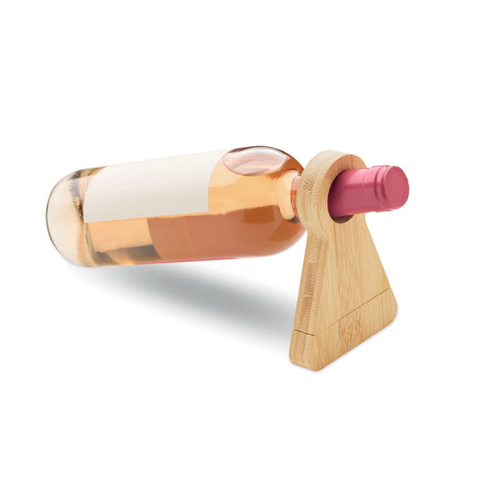 STANDTURN - Soporte y abrebotellas bambú con botella de vino rosa apoyada en el soporte de bambú.