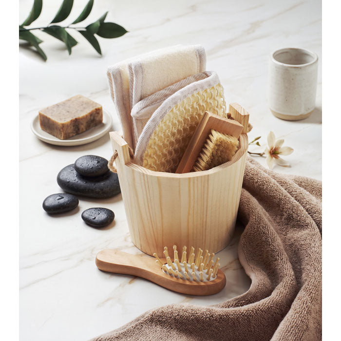 SELFCARE - Set de baño en cubo de madera con cepillos y productos de baño en un ambiente relajante.