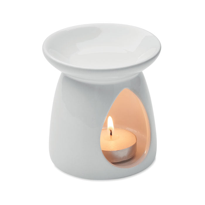SAGRADA - Quemador de vainilla con vela en cerámica blanca con vela de té encendida.