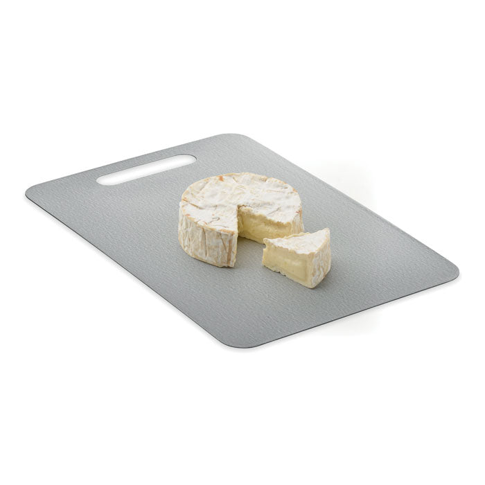PLATI + - Tabla de cortar de acero M con queso en la superficie.