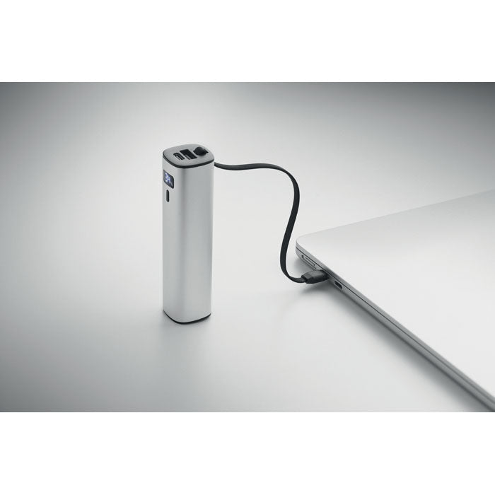 POWERTUBE - Powerbank 5000mAh PD 20W conectado a un ordenador portátil, mostrando su diseño en aluminio reciclado.