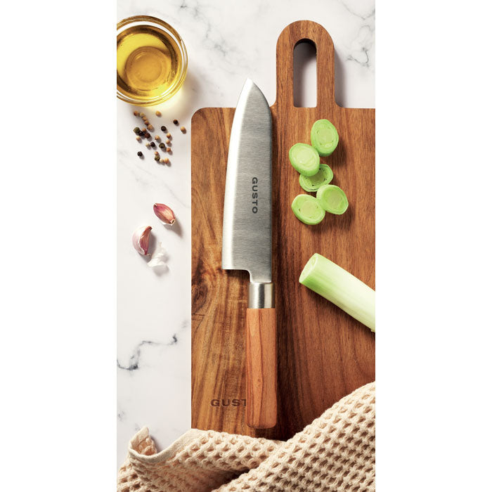 SLICE - Cuchillo chef madera de haya sobre una tabla de cortar, rodeado de ingredientes frescos.