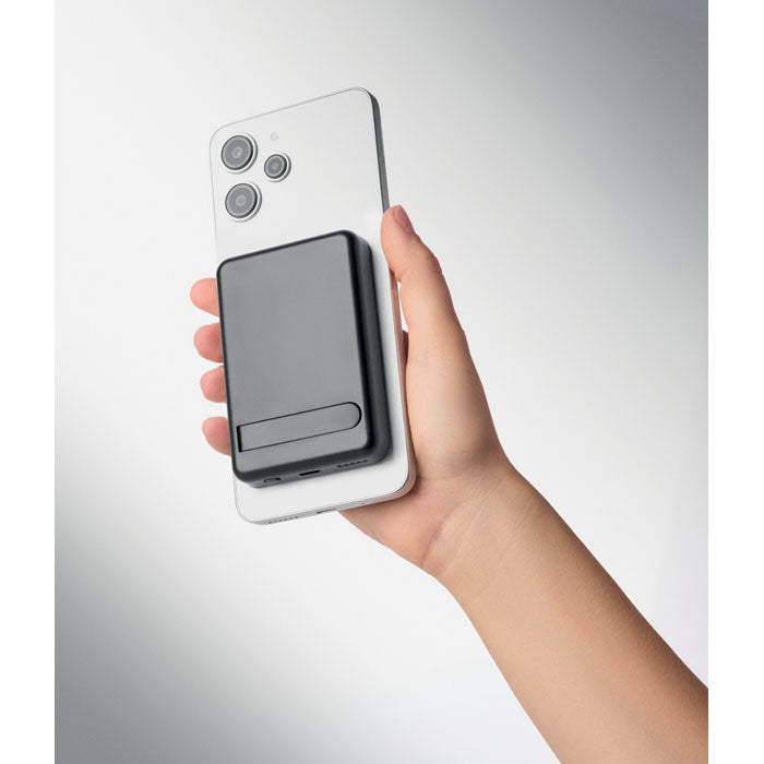 ATLAS - Powerbank magnético 5000mAh acoplado a un teléfono inteligente en una mano.