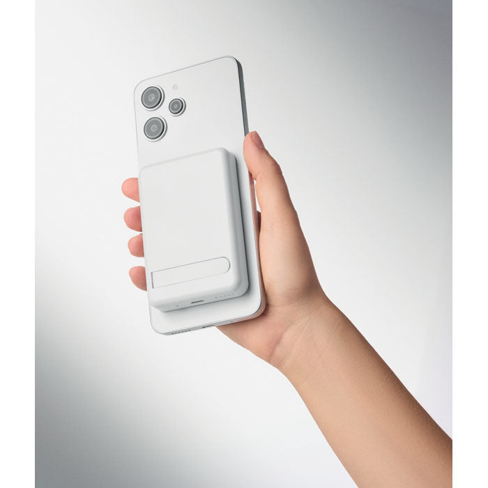 ATLAS - Powerbank magnético 5000mAh en mano, mostrando su diseño y uso con un teléfono móvil.